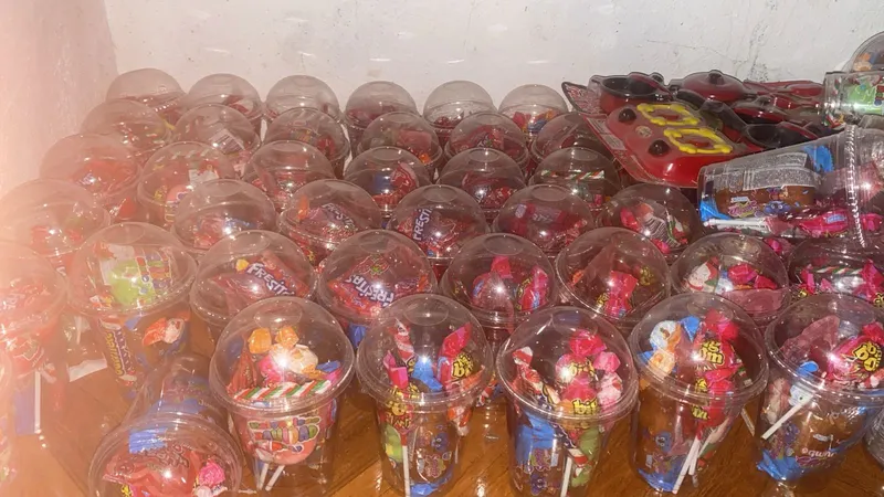Vasitos de dulces preparados para entrega a niños en evento navideño
