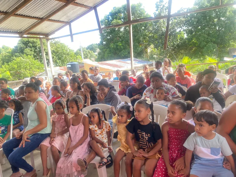 Niños y familias reunidos en evento comunitario bajo techo